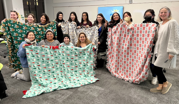 Dr. Fisher-Maltese and students hold up their completed blankets.