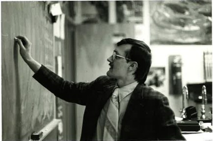 Photo of Tom Giska writing on a chalkboard