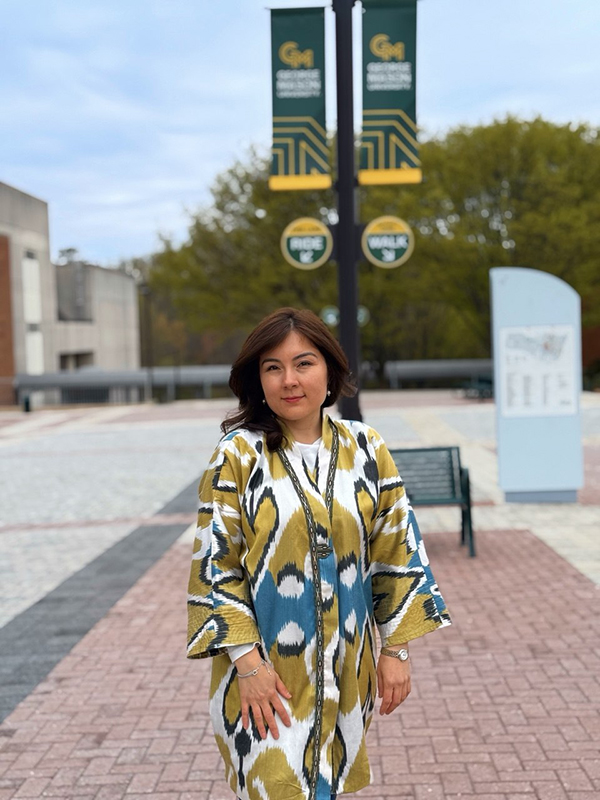 Dildora Khakimova in front of George Mason University banners